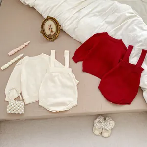 Flat lay of baby knitted cardigan and romper set with hollow lace details and cozy textures