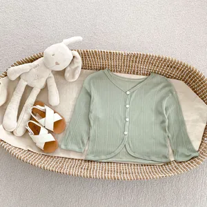 Dettaglio cardigan in maglia verde chiaro per neonati con scollo a V e costine