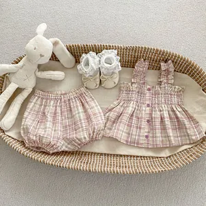 Flachbild von rosa kariertem Kleinkind-Set mit Rüschentop, Pumphose und Spitzenschuhen