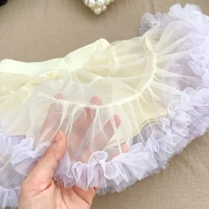 Macro detail of breathable light yellow mesh tulle skirt with purple wavy lace edges