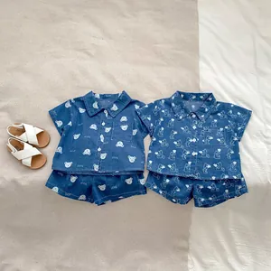 Dettaglio di completi estivi in denim per bambini con stampe di orsi e fiori su camicie