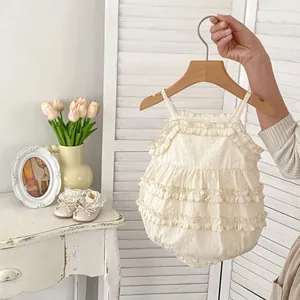 Detail of infant ruffle romper in beige cotton with matching lace trim toddler shoes