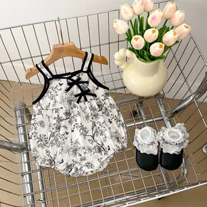 Detailed view of floral baby romper with butterfly prints and delicate black lace bow accents