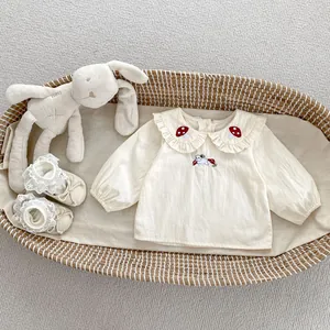 Dettaglio camicia crema per neonata con colletto ricamato a fungo e motivo a coniglio