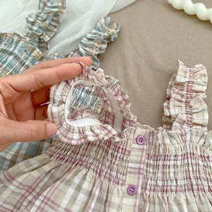Detail von kariertem Baby-Mädchen-Oberteil mit elastischem Bund und Rüschenverzierung