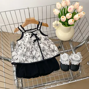 Detail of floral infant bodysuit with black bow, lace socks and shoes in a cart