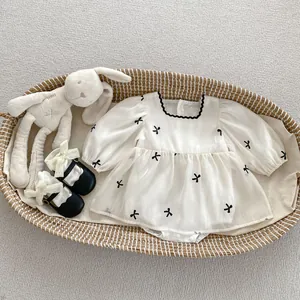 Top view of baby girl white mesh bodysuit dress with black bows and cute black shoes