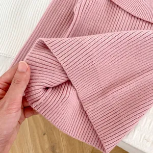 Detailed view of elastic hem and textured rib-knit fabric on pink girls' sweater