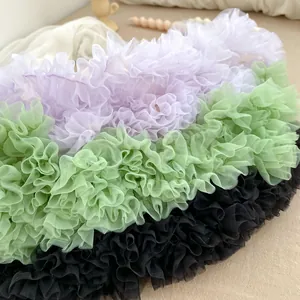 Close-up of layered ruffle tulle fabric in purple, green, and black for girls tutu skirts