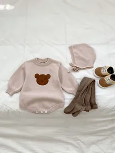 Détail de la barboteuse en tricot rose avec broderie ours, bonnet assorti et chaussettes