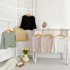 Dettaglio di cardigan in maglia a coste colorata nei toni verde, giallo, viola e bianco
