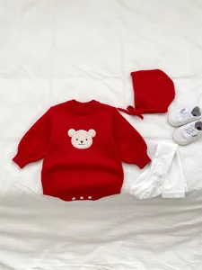 Vue à plat d'un barboteuse en tricot rouge pour bébé avec motif ours et bonnet