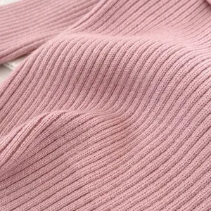 Detailed macro view of soft pink ribbed knit texture for girls' long sleeve sweater