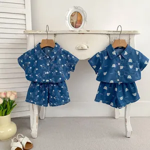 Dettaglio di completi in denim per bambini con stampe di cartoni animati e camicie estive