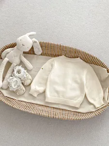 Detail van de gebreide textuur van babyvestje met kanten schoentjes en knuffel