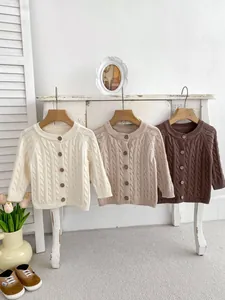 Detailed cable knit texture and wooden buttons on infant cotton cardigan sweaters