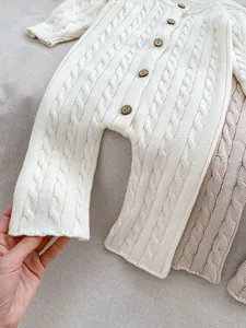 Dettaglio della maglia a treccia e bottoni in legno retrò su tutina bimbi