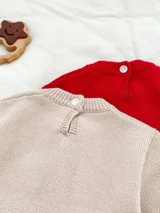 Détail de combinaisons en tricot pour bébé avec col rond côtelé et bouton au dos