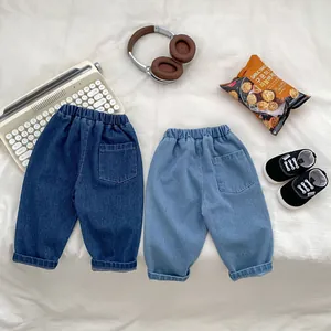 Flat lay of kids' solid color denim jeans featuring elastic waist and rolled cuffs