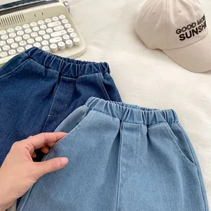 Detail of elastic waistbands and side pockets on dark and light blue denim shorts
