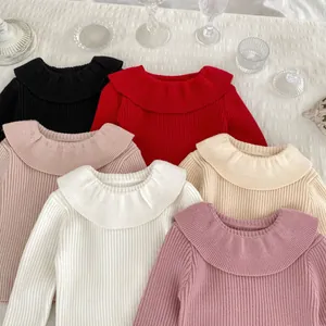 Flat lay of colorful girls' knit sweaters with ruffled collars in six vibrant colors