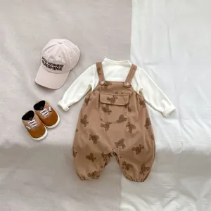 Detalle del pelele de pana marrón con estampado de osos y camiseta de manga larga para bebé