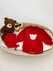Détail du body en tricot rouge pour bébé avec broderie ours et bonnet assorti