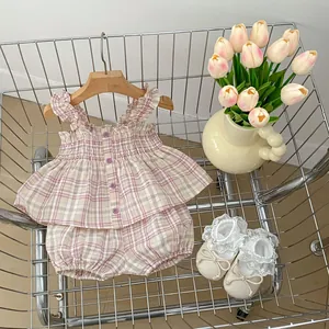 Detail eines Baby-Mädchen-Sommer-Sets mit kariertem Oberteil und Pumphose im Korb