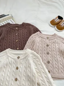 Detail of cable knit patterns and wooden buttons on vintage children cardigans