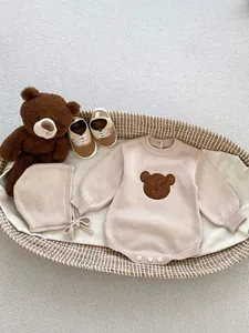 Gros plan détaillé sur un barboteuse en tricot pour bébé avec broderie d'ours