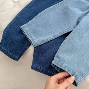 Detail of soft denim texture on children's straight-leg jeans in dark and light blue