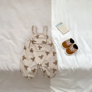 Detalle de pelele para bebé en pana beige con estampado de osos y tirantes