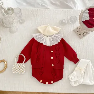 Flat lay of baby girl vintage knit cardigan and romper set with a pearl handbag