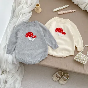 Detail of knitted baby rompers with mushroom jacquard in grey and beige tones