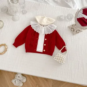 Detailed flat lay of a red hollow diamond knit cardigan with lace collar and accessories