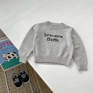 Detail of grey knit sweater for children featuring Someone Better cursive embroidery