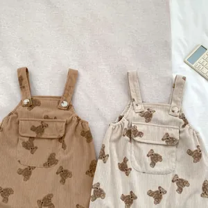 Detalle de mamelucos de pana para bebé con estampados de osos y tirantes con botones