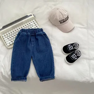 Detail of dark blue denim trousers for boys featuring a comfortable elastic waistband