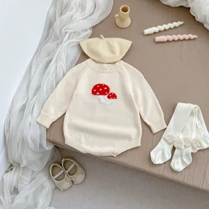 Detail of baby knit romper set with mushroom embroidery and angel wing tights