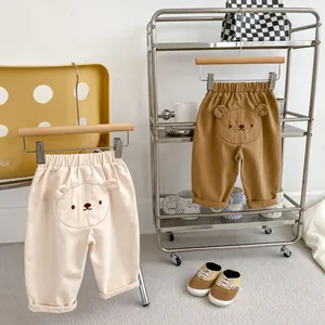 Dettaglio dei pantaloni per bambini con ricamo orsetto 3D e vita elasticizzata