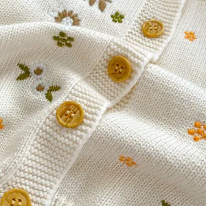 Gebreid vest voor meisjes in crème met bloemendessin en houten knoopjes