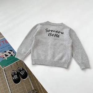 Dettaglio in piano del cardigan grigio a maglia per bambini con ricamo sul retro