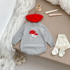 Detail of baby knitted grey romper with red mushroom pattern and matching accessories