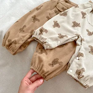 Detalle de mamelucos de pana para bebés con estampados de osos y broches para cambiar pañales