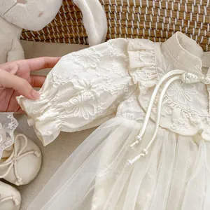 Detail of baby girl bodysuit with traditional knots, floral embroidery and mesh skirt