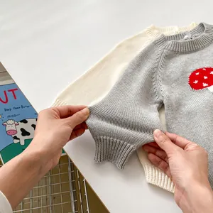 Detail of baby knit romper showing elastic ribbed cuffs and soft mushroom pattern fabric