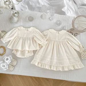 Flachbild von cremefarbenen Baby-Sets mit Peter-Pan-Kragen und Rüschendetails