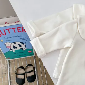 Detail eines weißen Baby-Langarmshirts aus Baumwolle mit weicher Rippstruktur und Rollbündchen