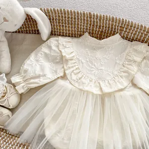 Detail of baby girl tulle dress featuring floral embroidery and elegant ruffle collar