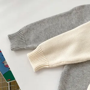 Detailed close-up of soft knit fabric texture and ribbed cuffs on baby rompers